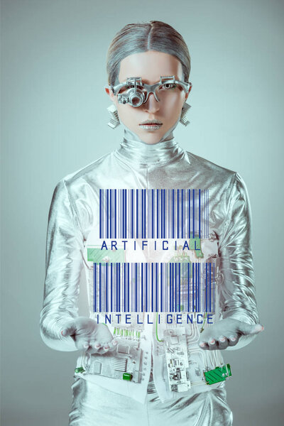 futuristic silver cyborg with barcodes and artificial intelligence in hands looking at camera isolated on grey, future technology concept 