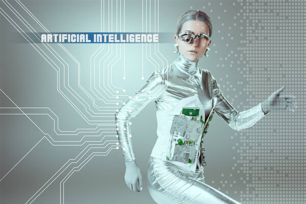 silver cyborg walking and looking at camera on grey with "artificial intelligence" lettering and digital data