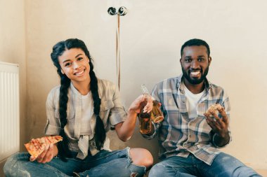 bira ve pizza ev yenileme yaparken katta oturan ile gülümseyen çift