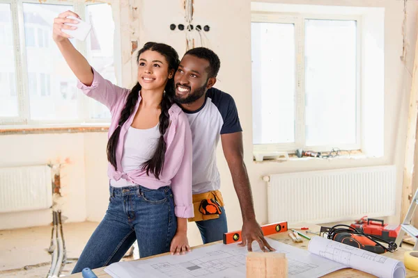 Cheerful African American Couple Taking Selfie Smartphone Table Blueprint Renovation — Free Stock Photo