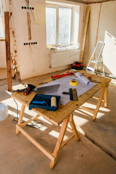 high angle view of room with table with blueprint and laptop during renovation of home