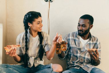 yenileme sırasında evde bira şişeleri tarafından tungur pizza ile mutlu Afrika kökenli Amerikalı çift