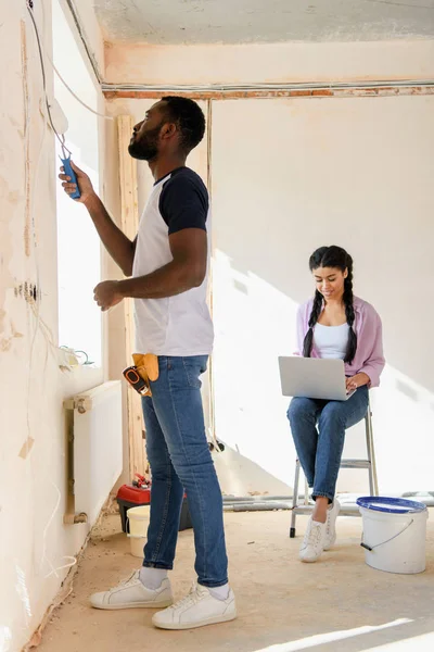 Side View African American Man Painting Wall While His Girlfriend — Free Stock Photo