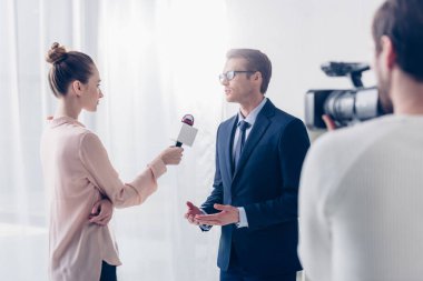 Ofiste güzel gazeteci video röportaj veren gözlük yakışıklı işadamı