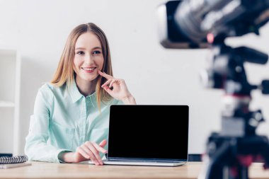 Office, Masa üstü boş ekran ile laptop vlog kayıt gülümseyen çekici kadın serbest meslek