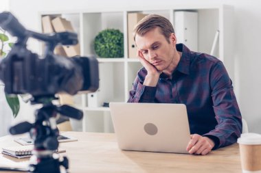 vlog kayıt ve office içinde laptop bakarak yorgun yakışıklı erkek video blogger