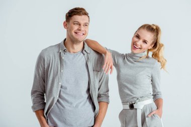 kameraya bakarak ve izole üzerinde gri poz güzel gülümseyen çift