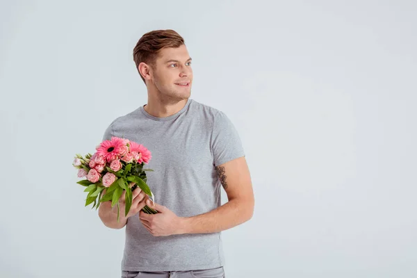 Красивий Чоловік Тримає Рожевий Квітковий Букет Дивиться Ізольовано Сірий — стокове фото