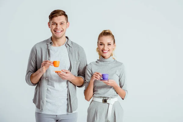 Sorrindo Casal Segurando Xícaras Café Olhando Para Câmera Isolada Cinza — Fotografia de Stock Grátis