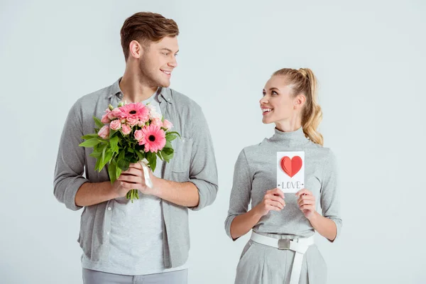 Pareja Feliz Mirándose Sosteniendo Tarjeta San Valentín Ramo Flores Aislados — Foto de Stock