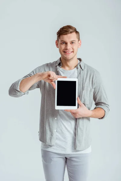 Улыбающийся Мужчина Серой Одежде Представляет Цифровой Планшет Чистым Экраном Изолированным — стоковое фото