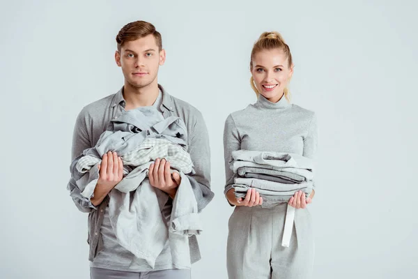 Beautiful Couple Looking Camera Holding Grey Clothes Isolated Grey — Stock Photo, Image
