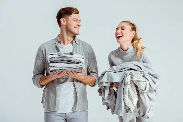 Beautiful Couple Holding Piles Grey Clothes Laughing Isolated Grey — Free Stock Photo