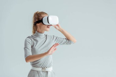Hava gri izole sanal gerçeklik deneyimi yaparken dokunmadan gri giyim ve vr kulaklık kız