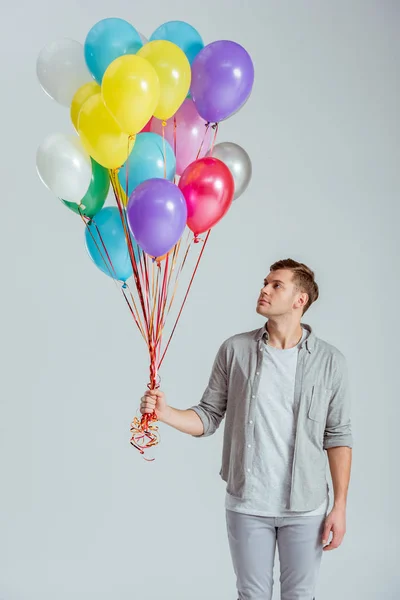 Bonito Homem Segurando Pacote Balões Coloridos Fundo Cinza — Fotografia de Stock