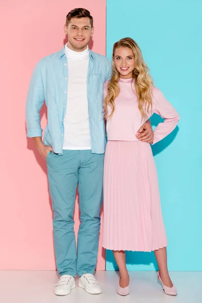 カメラ目線とピンクと青の背景でポーズ美しい笑顔のカップル — ストック写真