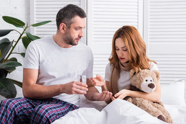 Husband Giving Pills Glass Water Sick Wife Bedroom — Stock Photo, Image