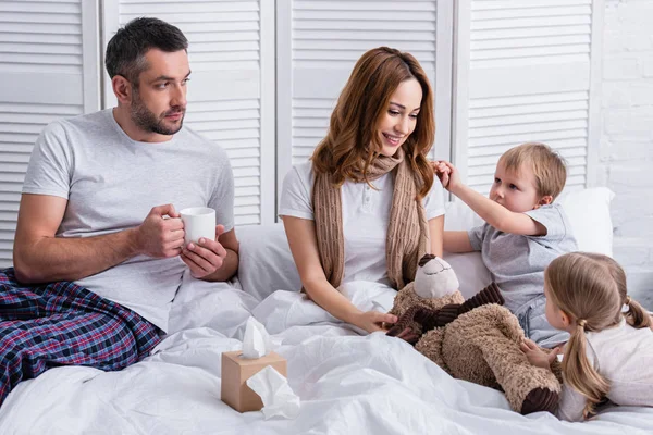 Ehemann Und Kinder Unterstützen Lächelnde Kranke Mutter Schlafzimmer — kostenloses Stockfoto