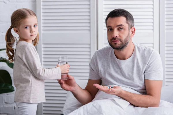 Figlia Che Bicchiere Acqua Papà Prendere Pillole Camera Letto Guardando — Foto Stock