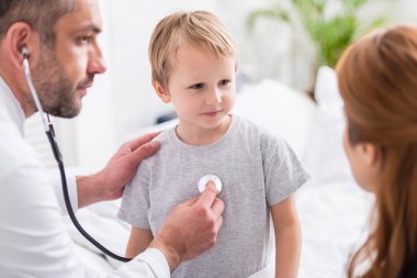 seçici odak pediatrist beyaz ceket hasta çocuk stetoskop ile incelenmesi
