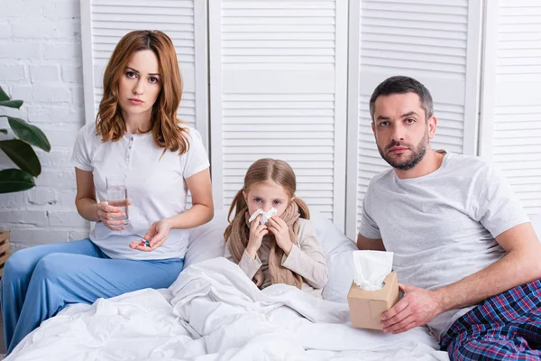 Padres Cuidando Hija Enferma Dormitorio Dándole Pastillas Vaso Agua Mirando — Foto de Stock