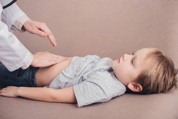 Imagen Recortada Pediatra Palpando Estómago Niño Enfermo Sofá Sala Estar — Foto de Stock