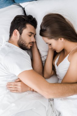 uyku ve yatakta kucaklayan genç çiftin üstten görünüm