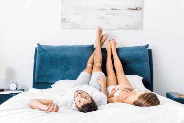 Junges Paar Liegt Mit Erhobenen Beinen Bett Während Mann Die — Stockfoto