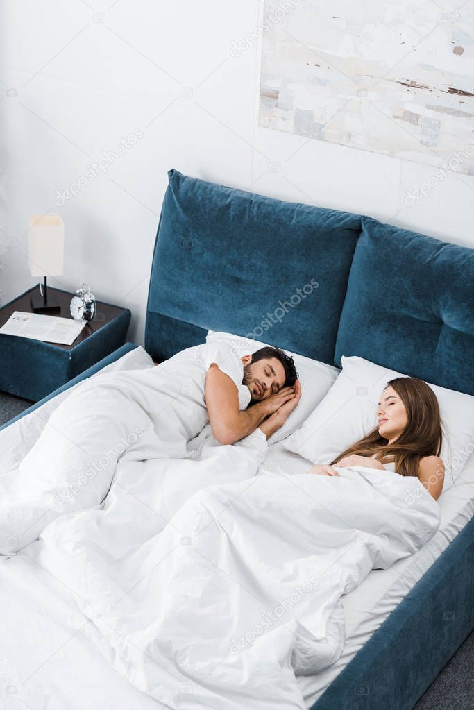 young couple sleeping together in bed