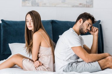 Genç çift pijama yatağa oturmuş depresif