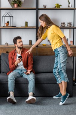 kızgın kız erkek arkadaşıyla kavga ve smartphone, parmakla işaret
