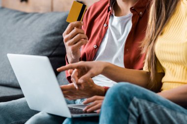 kredi kartı tutan ve kız online alışveriş yaparken insanın kırpılmış görünümü