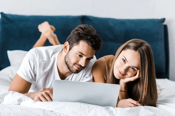 Junges Paar Liegt Bett Und Benutzt Laptop — kostenloses Stockfoto