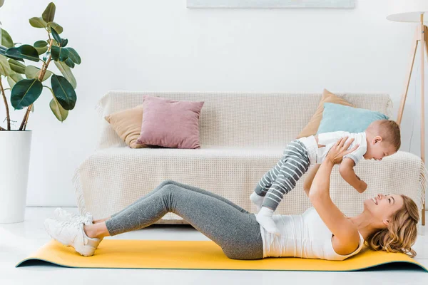 Mãe Deitada Tapete Fitness Segurando Bebê Filho — Fotografia de Stock