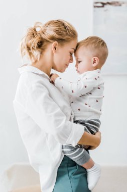 çekici anne kucaklayan güzel yürümeye başlayan çocuk oğul evde
