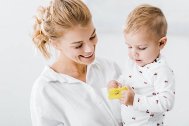 şirin bebek evlat oyuncak ile tutan gülümseyen kadın