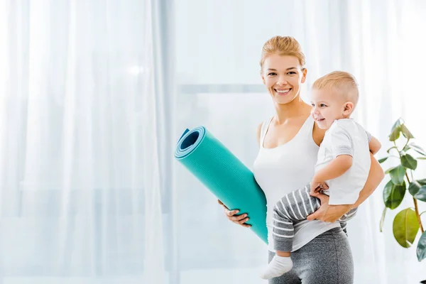 Attractive Woman Sportswear Looking Camera Holding Fitness Mat Smiling Toddler — Stock Photo, Image