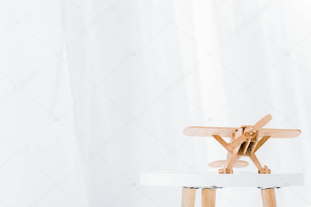 wooden plane model on white table at home