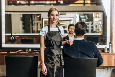 güzel genç Kuaför Güzellik Salonu sandalyede oturan erkek istemci ise kamera gülümseyen 