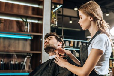 Genç kuaför kırpma sakal yakışıklı istemciye güzellik salonu