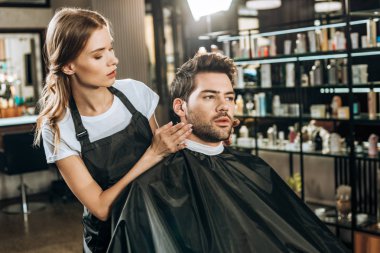 güzel genç Kuaför Güzellik Salonu yakışıklı erkek istemciye saç modeli yapmak