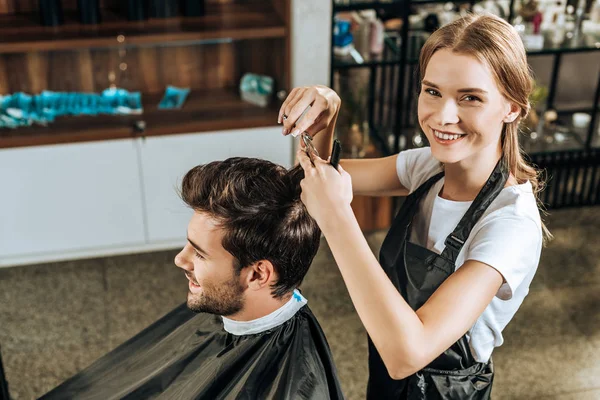 Visão Alto Ângulo Cabeleireiro Sorrindo Para Câmera Cortar Cabelo Para — Fotografia de Stock