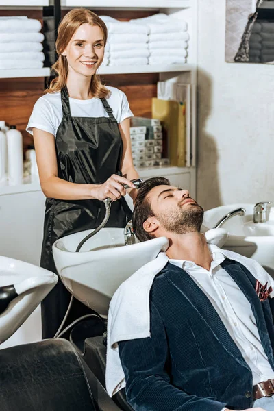 Young Hairstylist Smiling Camera While Washing Hair Handsome Young Male — Free Stock Photo