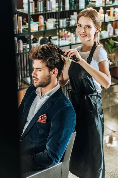 Young Female Hairdresser Smiling Camera While Drying Hair Handsome Client — Free Stock Photo