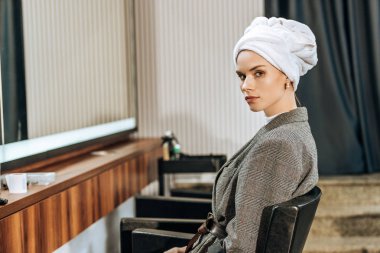 oturma ve güzellik salonu kamerada bakarak kafa havluya çekici genç kadın