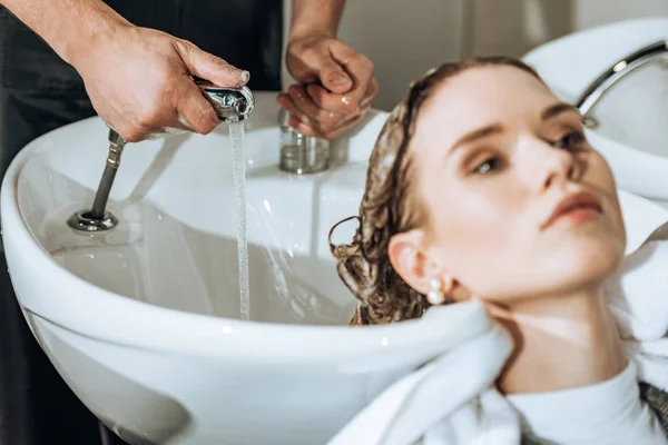 Обрезанный Снимок Парикмахера Проверяющего Воду Моющего Волосы Молодой Женщине Салоне — стоковое фото