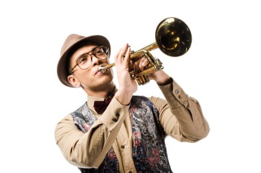young mixed race man in stylish hat and eyeglasses playing on trumpet isolated on white  clipart