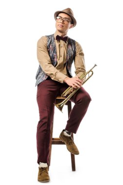 Trompet tutarak ve üzerinde beyaz izole sandalye üzerinde oturan karışık yarış erkek jazzman