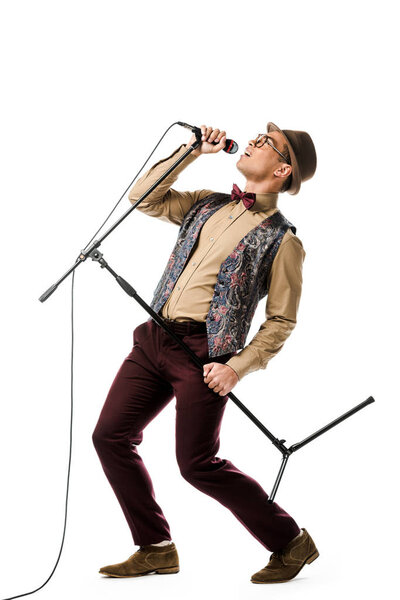 emotional stylish mixed race male musician holding microphone and singing isolated on white