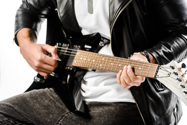 partial view of male rock musician in leather jacket playing on electric guitar isolated on white